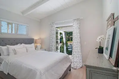 a white bedroom with a large bed and a window at 190 Walnut in Carlsbad