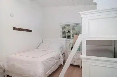 a white bedroom with a bunk bed and a ladder at 190 Walnut in Carlsbad