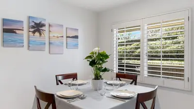 a white dining room with a table and a window at Walk to Beach Pool Hot Tub Private Patio Parking Seabreeze Retreat in Dana Point