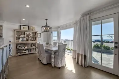 a dining room with a table and chairs and a window at 3636 Carlsbad Blvd - Lower in Carlsbad