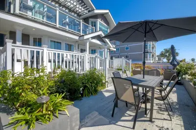 a patio with an umbrella and a table and chairs at 3636 Carlsbad Blvd - Lower in Carlsbad