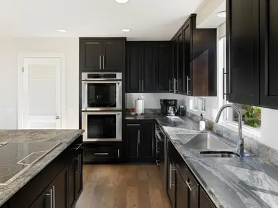 a kitchen with black cabinets and stainless steel appliances at 327 Hillcrest Drive in Encinitas