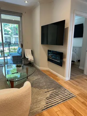 a living room with a flat screen tv on a wall at Irvine Gem Luxury condo 31 days min near Irvine Business & UCI Hospital in Irvine