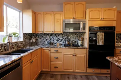 a kitchen with wooden cabinets and stainless steel appliances at Family fun near the beach-sold in Oceanside
