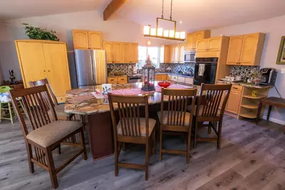 a kitchen with a table and chairs and a kitchen with yellow cabinets at Family fun near the beach-sold in Oceanside