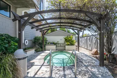 a pergola over a swimming pool in a backyard at Walk to the Beach Balcony Sunset Ocean Views in Oceanside