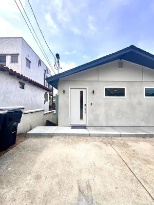 a white house with a blue roof and a driveway at Titus Retreat in San Diego