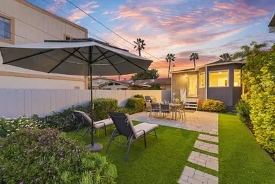 a backyard with a table and chairs and an umbrella at Newly Renovated Pacific Beach Home with Private Yard and AC in San Diego