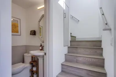 a bathroom with a sink and a toilet and stairs at Steps to the Beach with Private Patio BBQ and Fire Pit in San Diego