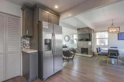 a kitchen with a stainless steel refrigerator and a dining room at Steps to the Beach with Private Patio BBQ and Fire Pit in San Diego