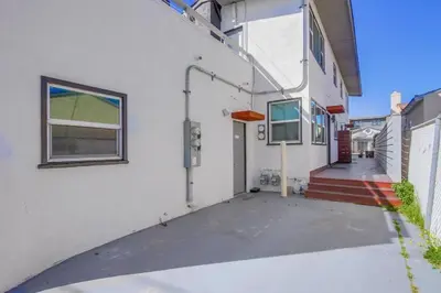 a white house with a driveway and a window at Steps to the Beach with Private Patio BBQ and Fire Pit in San Diego