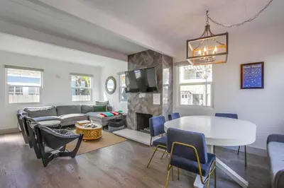 a living room with a table and a fireplace at Steps to the Beach with Private Patio BBQ and Fire Pit in San Diego