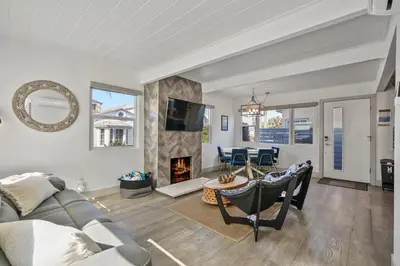 a living room with a couch and a fireplace at Steps to the Beach with Private Patio BBQ and Fire Pit in San Diego