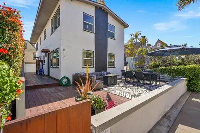 a house with a patio and an umbrella at Steps to the Beach with Private Patio BBQ and Fire Pit in San Diego