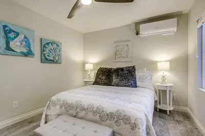 a white bedroom with a bed and a window at Bayside Getaway Steps to the Ocean with AC Private Patio BBQ Family and Pet Friendly in San Diego