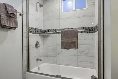 a bathroom with a shower and a bath tub at Bayside Getaway Steps to the Ocean with AC Private Patio BBQ Family and Pet Friendly in San Diego