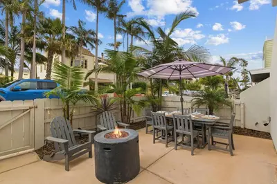 a patio with a table and chairs and an umbrella at Bayside Getaway Steps to the Ocean with AC Private Patio BBQ Family and Pet Friendly in San Diego