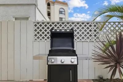 a black and white stove in front of a fence at Bayside Getaway Steps to the Ocean with AC Private Patio BBQ Family and Pet Friendly in San Diego