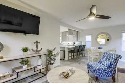 a living room with a tv and a couch and a table at Bayside Getaway Steps to the Ocean with AC Private Patio BBQ Family and Pet Friendly in San Diego