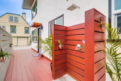 a house with a wooden fence with plants at Mission Beach Escape Near Ocean and Bay with Private Balcony BBQ and Garage Parking in San Diego
