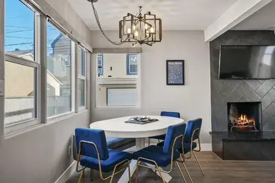 a dining room with a table and chairs and a fireplace at Mission Beach Escape Near Ocean and Bay with Private Balcony BBQ and Garage Parking in San Diego