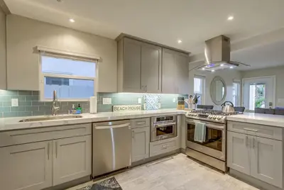 a large kitchen with white cabinets and a sink at Bayside Retreat with Water Views Near Beach with AC and Private Patio in San Diego