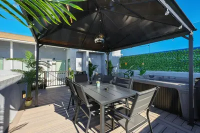 a table and chairs under an umbrella on a deck at Harborside Suite 10 with Hot Tub and King Bed in San Diego