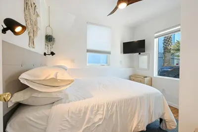 a white bedroom with a bed and a tv at Harborside Suite 08 with Hot Tub in San Diego