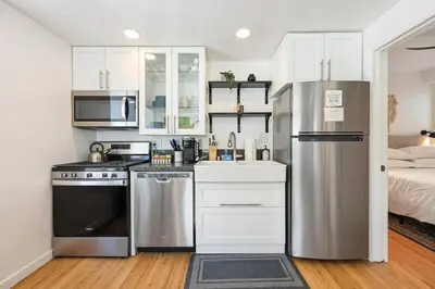 a kitchen with a stainless steel refrigerator and a bed at Harborside Suite 08 with Hot Tub in San Diego