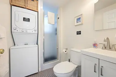 a white bathroom with a toilet and a sink at Harborside Suite 08 with Hot Tub in San Diego