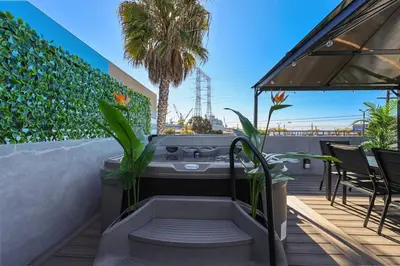 a hot tub on a patio with a palm tree at Harborside Suite 06 with Hot Tub and King Beds in San Diego