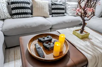 a living room with a table with remote controls on it at Entire Private Home with 4 Bedrooms 2 Bathrooms, Spacious, Lux King Bed, Ranch Style, Prime Area, Available Now in La Mesa
