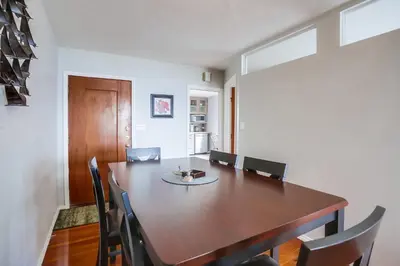 a dining room with a wooden table and chairs at Rooftop patio ocean views surf break steps away in San Diego