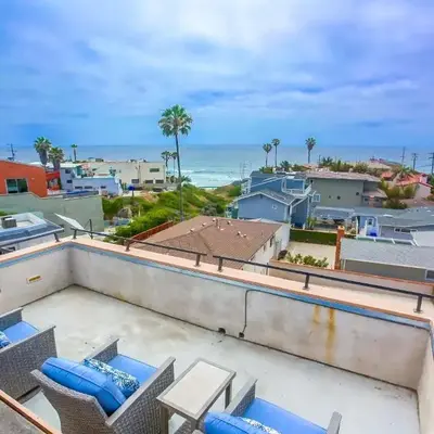 Rooftop patio ocean views surf break steps away