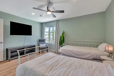 a bedroom with two beds and a flat screen tv at Tropical Bliss - 5BR Pool Spa Games 12 min to dwtn in San Diego