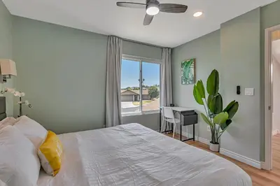 a bedroom with a bed and a window and a desk at Tropical Bliss - 5BR Pool Spa Games 12 min to dwtn in San Diego