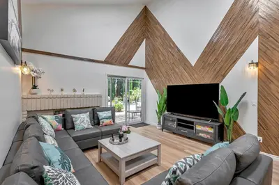 a living room with a couch and a flat screen tv at Tropical Bliss - 5BR Pool Spa Games 12 min to dwtn in San Diego