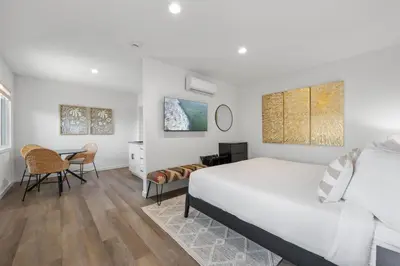 a white bedroom with a bed and a desk at South O Bungalow 11 - Luxury King Suite + Patio in Oceanside