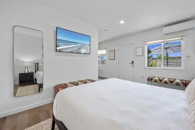 a white bedroom with a bed and a window at South O Bungalow 10 - Premium Deluxe King Studio + Patio in Oceanside
