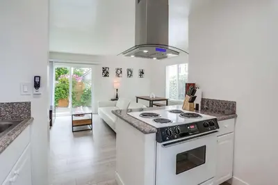 a kitchen with a stove and a living room at ocean views 3 blocks to beach AC downstairs in San Diego