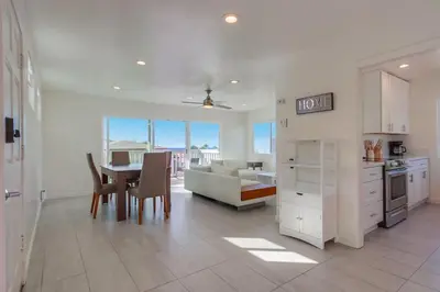 a kitchen and living room with a table and a couch at ocean views 3 blocks to beach AC downstairs in San Diego