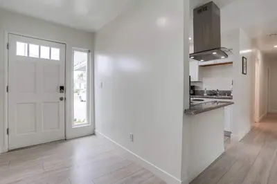 an empty kitchen with a white door and a counter at ocean views 3 blocks to beach AC downstairs in San Diego