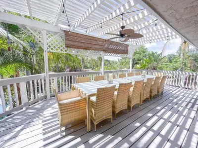 a dining table and chairs on a white deck at Paradise Lagoon Resort Style Pool Getaway in La Mesa