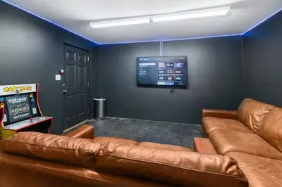 a living room with a leather couch and a video game at Paradise Lagoon Resort Style Pool Getaway in La Mesa