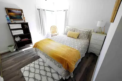 a bedroom with a bed and a chair and a window at Near SoCal sports complex, Frontwave Arena-Sold in Oceanside