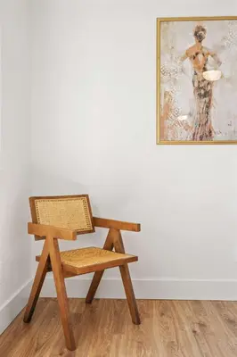 a wooden chair sitting in a room with a painting at The Oasis in Escondido