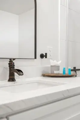 a white bathroom sink with a mirror above it at The Oasis in Escondido