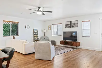 a living room with white walls and a flat screen tv at The Oasis in Escondido
