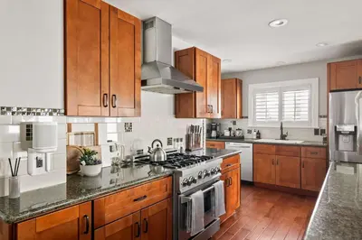 a kitchen with wooden cabinets and a stove top oven at Cozy 3BR Steps to Dining & Attractions in San Diego