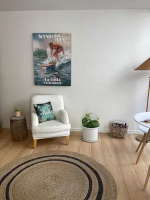 a living room with a white chair and a rug at La Jolla Suite & Beach Access in San Diego